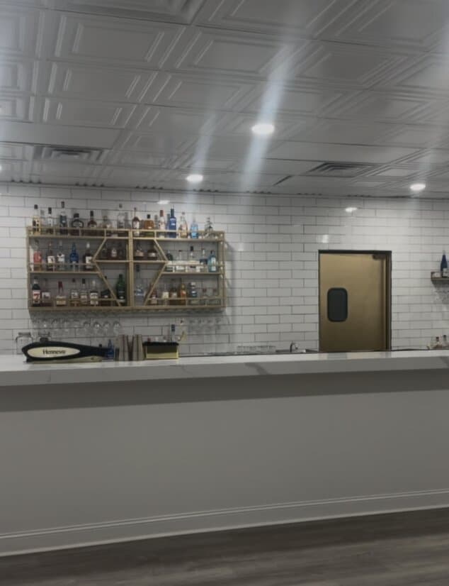 Private in-house bar with white subway tile and a fully stocked back shelf