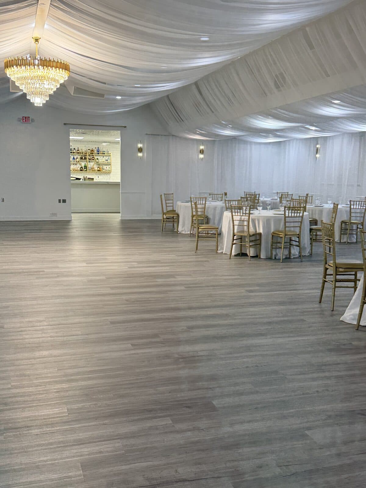 Reception tables with the built-in bar visible in the background of the banquet hall