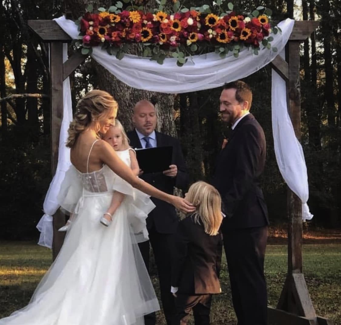 Wedding ceremony under floral arch at venue