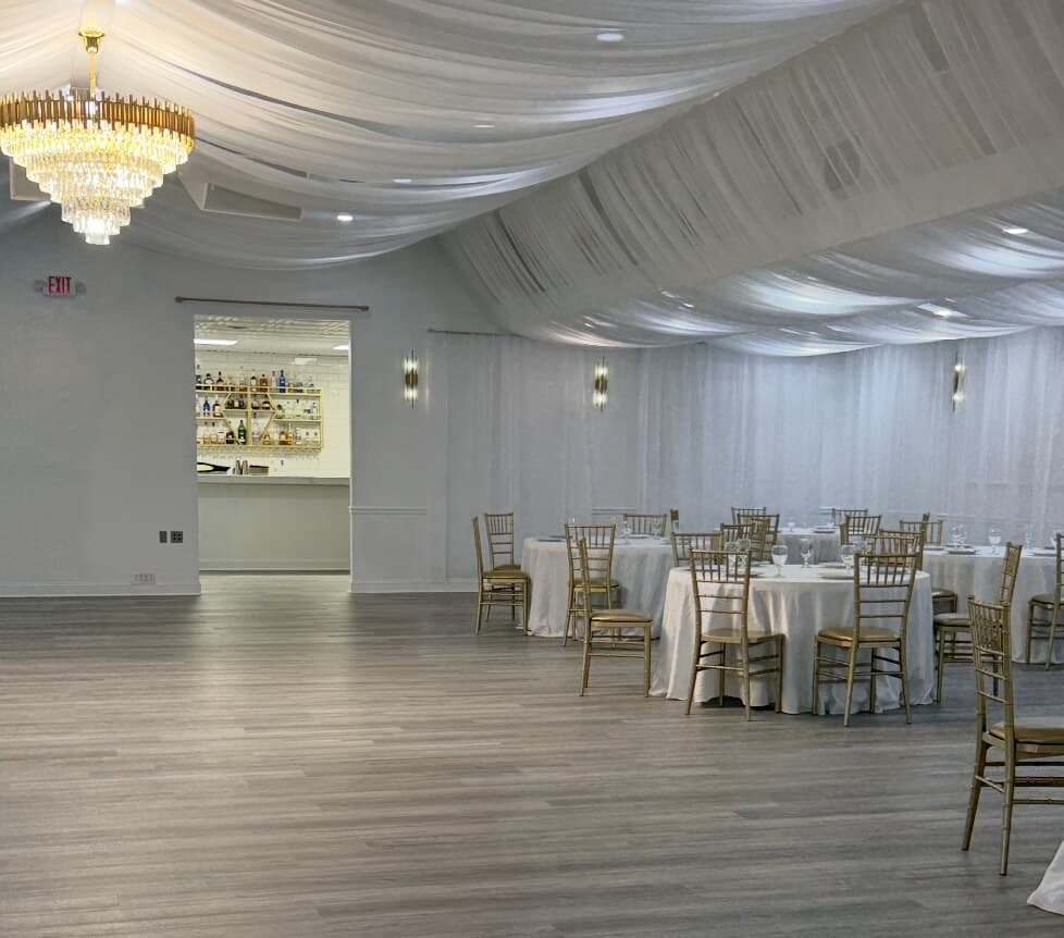 Havenwing banquet hall interior with draped ceilings, crystal chandelier and reception tables